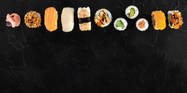 寿司设置，全景拍摄从上方的黑色背景。许多不同的寿司，手握寿司和卷，有鱼和蔬菜，有拷贝空间图片下载
