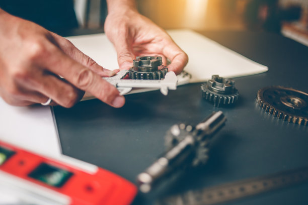 机械工程师正在用卡尺测量齿轮。设计机器图片下载