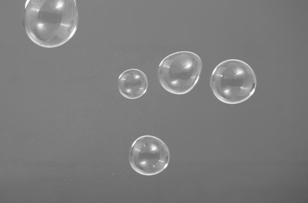 真实的肥皂泡漂浮在工作室的背景上，由肥皂洗发精制成，被人吹来代表轻风和清新的心情图片下载