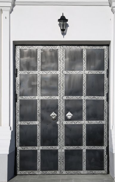 白色墙壁上的入口金属门。图片下载