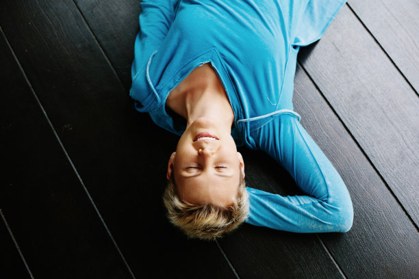 微笑的短发女人躺在⽊制背景上，⾯部肖像图片下载