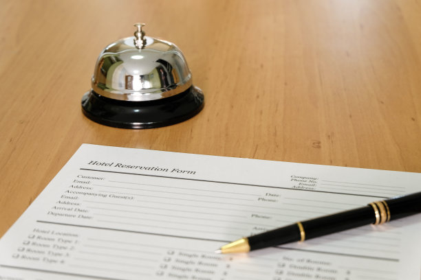 酒店预订单和豪华钢笔在礼宾台。用铃招呼客人要求服务，注意。酒店、酒店的经营理念。图片下载