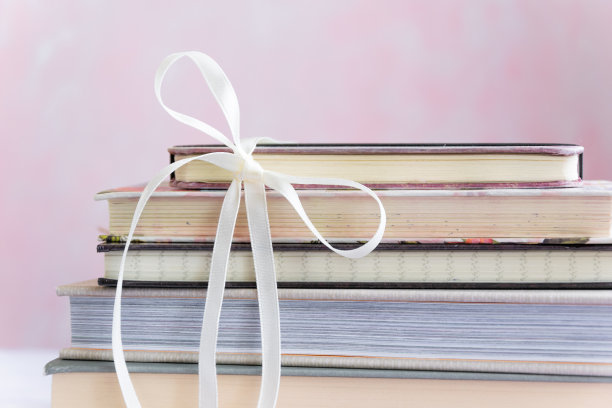 一堆用蝴蝶结捆着的书图片下载