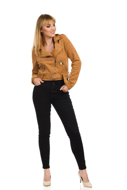 穿着棕色绒面革夹克的年轻女子站在口袋里，看着别处图片下载