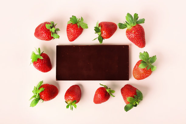 草莓和巧克力，粉色背景，相框。布局设计。顶部视图，放置文本。图片下载