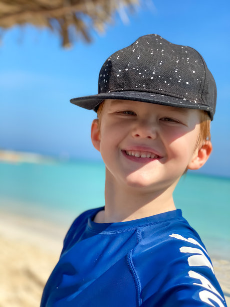 小红发男孩看着相机，在海滩微笑图片下载