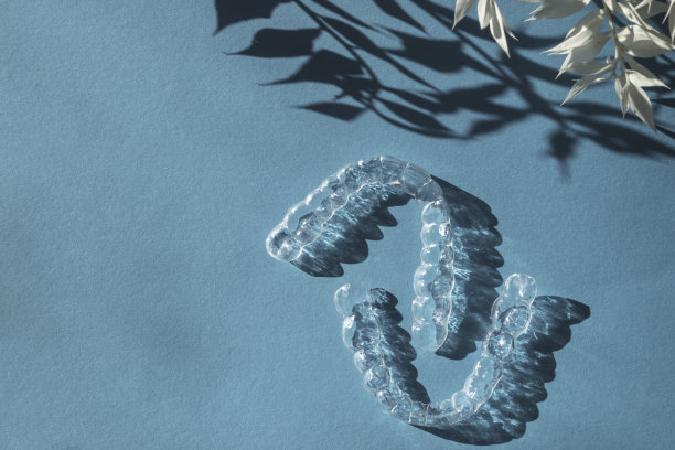 看不见的对准齿支架上的蓝色背景与花的影子图片下载