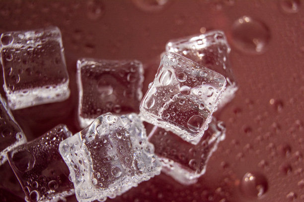 冰块/一些不同的冰块放在红色背景上的镜像桌子上图片下载