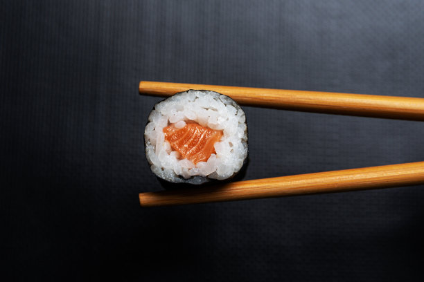 寿司的库存照片与筷子在黑色的背景。日本料理组成。图片下载