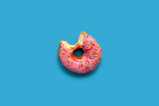 被咬的甜甜圈在蓝色的背景。图片下载