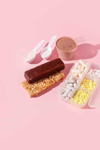 蛋白粉，汤勺，充满活力的麦片棒，维他命丸，粉红色背景与阴影-概念运动饮食，保健，营养适合健身食品，copyspace图片下载