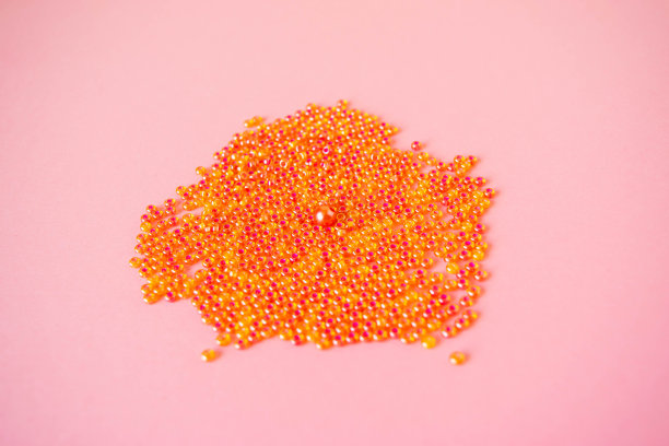 在淡粉色的背景上撒满了粉红色的珠子。图片下载