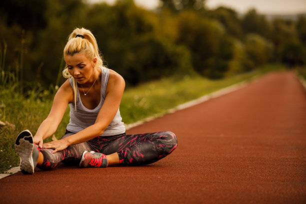 中年运动女性在跑步后伸展她的下半部的全长图片下载