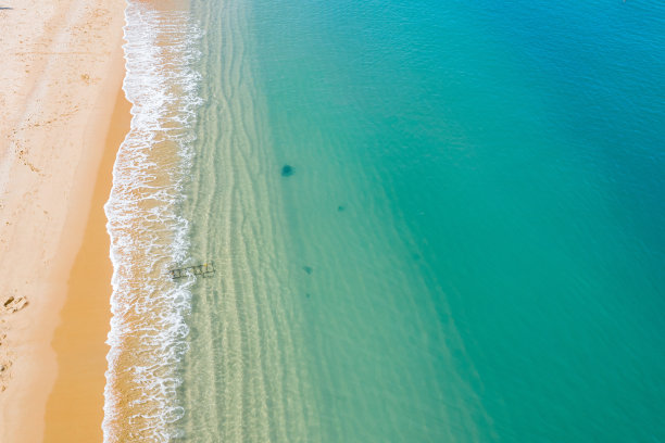 绿松石海浪到达海岸线的鸟瞰图素材图片