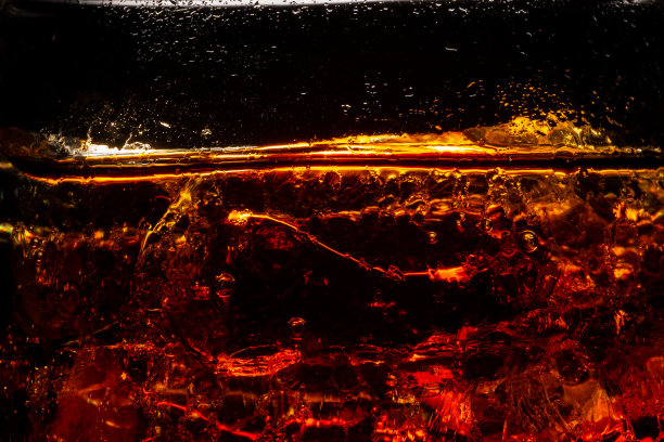 深色背景上有冰块的软饮杯。庆祝派对概念中的可乐杯。图片下载