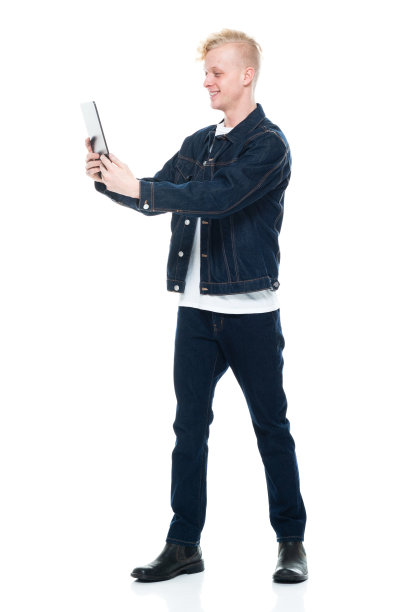 白人年轻男性穿着牛仔裤站在白色背景下使用平板电脑图片下载