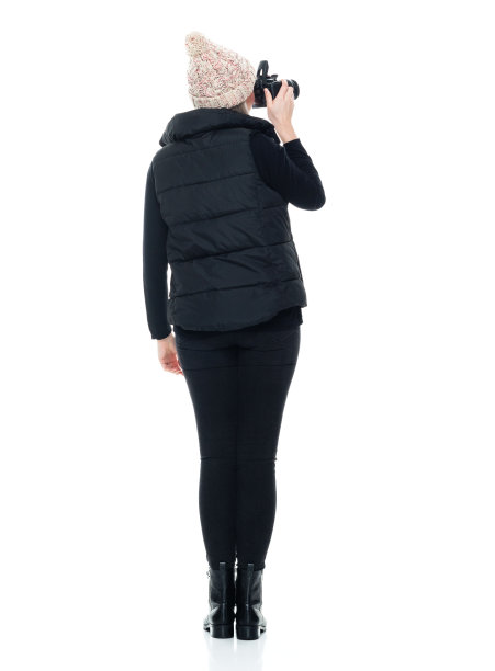 白人年轻女性游客站在白色背景下，穿着夹克，拿着相机图片下载