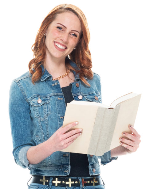 白人年轻女学生穿着暖和的衣服，拿着课本，站在白色背景前图片下载
