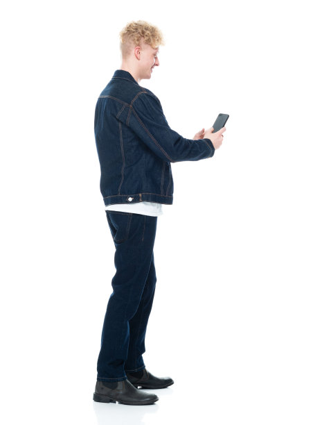 白人男性穿着牛仔裤站在白色背景下使用手机图片下载