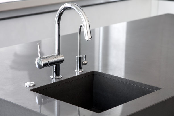 空白厨房水槽深灰色大理石与铬水龙头在一个干净的厨房与光滑的工作表面，关闭水龙头水槽与复制空间。图片下载