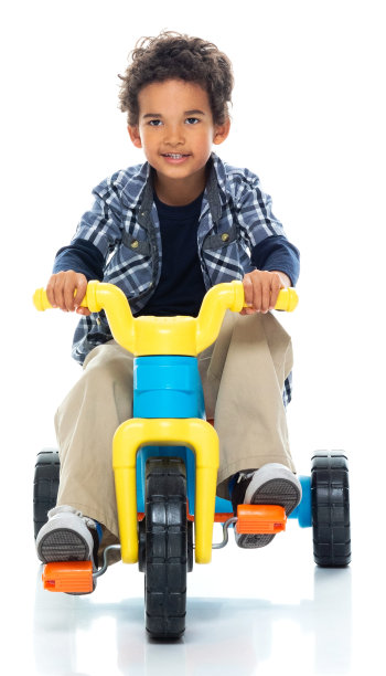 男孩在白色背景前骑自行车图片下载