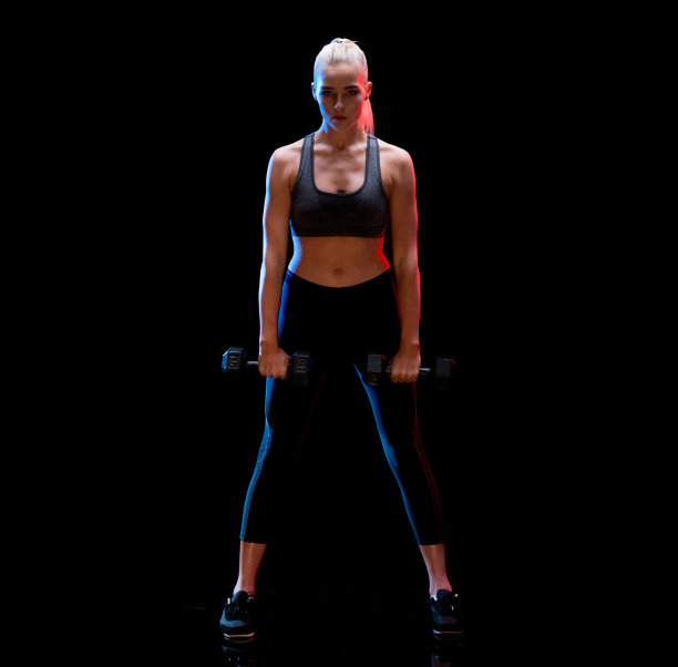 在黑色背景前穿着运动文胸进行交叉训练图片下载