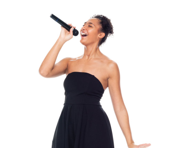 非裔美国女性穿着裙子手持麦克风在白人背景前跳舞图片下载