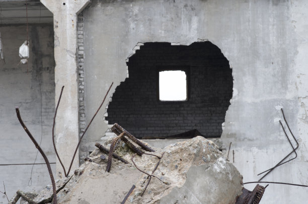 这是一座大型混凝土建筑倒塌后留下的残迹，墙上有个洞。图片下载