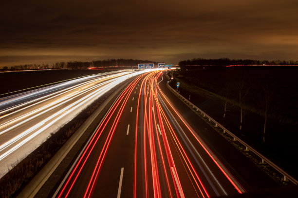 公路在黑暗中，车灯亮着图片下载