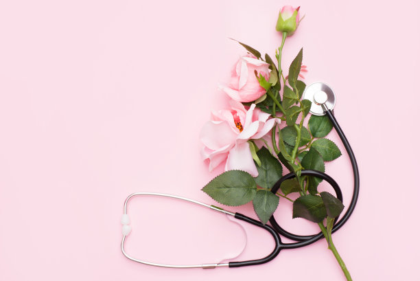 粉红色背景上的玫瑰花束和听诊器。国家医生日。护士节快乐。顶部视图与复制空间图片下载