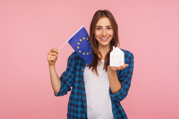 友好幸福的女人站在纸房子和欧盟旗帜的肖像图片下载