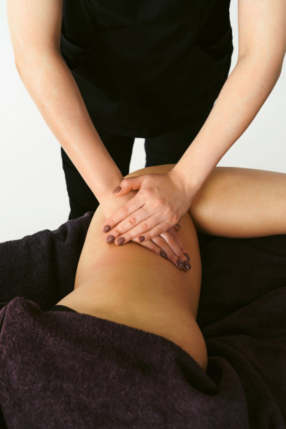 在美容院为年轻女性进行腿部反脂肪按摩。健康中心水疗燃烧完美肌肤脂肪。健康的生活方式。白色背景隔离图片下载