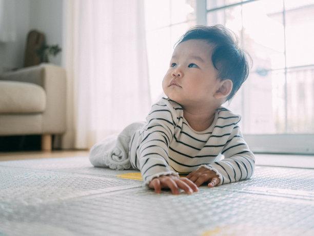 小男孩在垫子上笑着。图片下载
