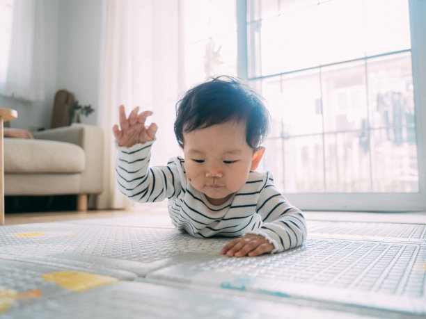 小男孩在垫子上笑着。图片下载