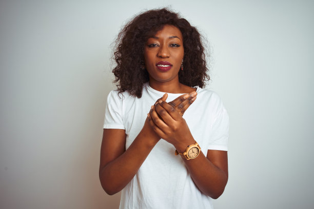 年轻的非洲裔美国妇女穿着t恤站在孤立的白色背景上手和手指疼痛，关节炎图片下载