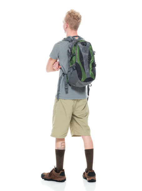白人年轻男性背包客徒步旅行在前面的白色背景穿着短裤和拿着包图片下载