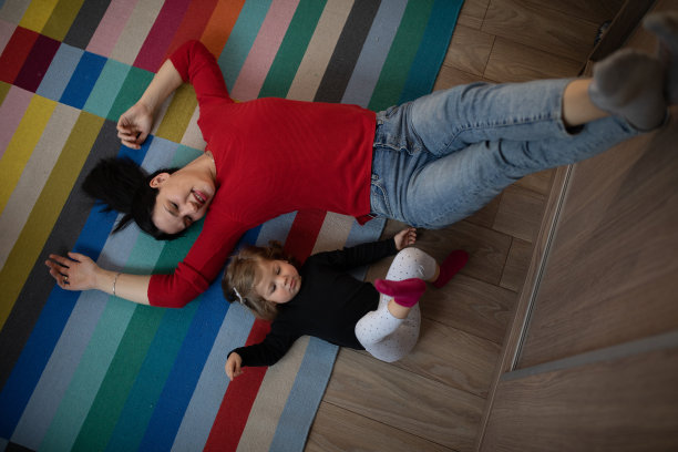 年轻的母亲和女儿躺在地板上图片下载