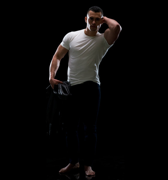 拉丁美洲和西班牙裔的年轻男性在黑人背景下穿着皮夹克图片下载