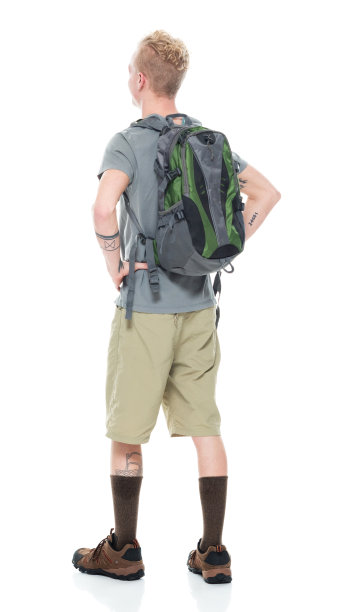 白人年轻男性背包客在白色背景下背着背包和拿着包徒步旅行图片下载