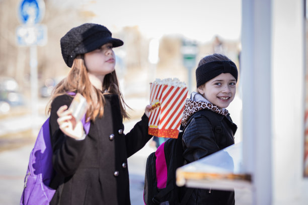 快乐的女学生们吃着爆米花笑着图片下载