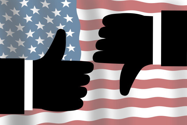 双手大拇指向上和向下，背景是美国国旗。美国总统选举概念。图片下载