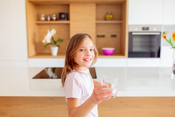 小女孩在厨房里从杯子里喝水图片下载