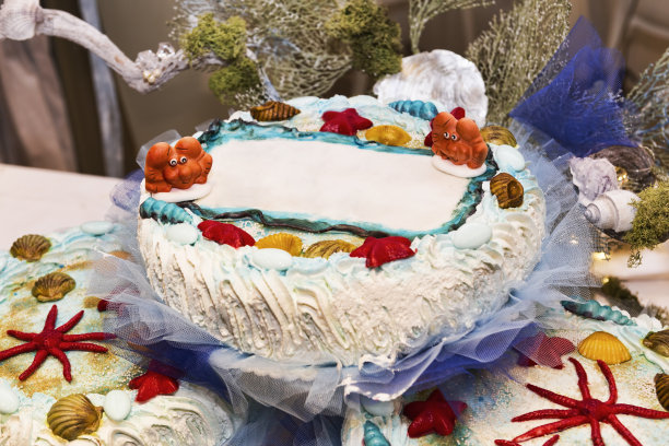 海洋主题彩色派对上的童年之美，蛋糕上覆盖着柔软的奶油和五彩缤纷的海洋动物造型糖渍杏仁图片下载