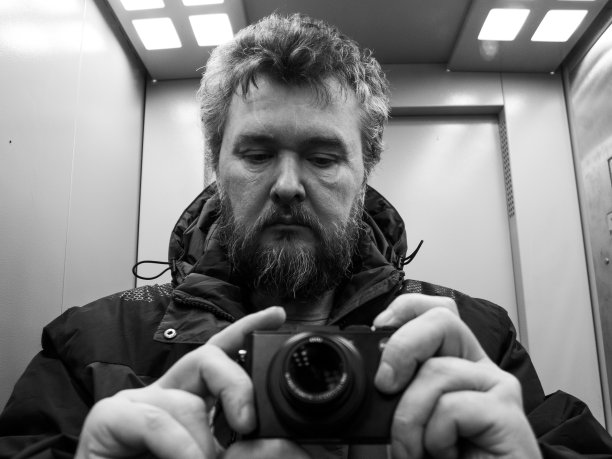 一个成熟的男人正在用一架袖珍照相机图片下载