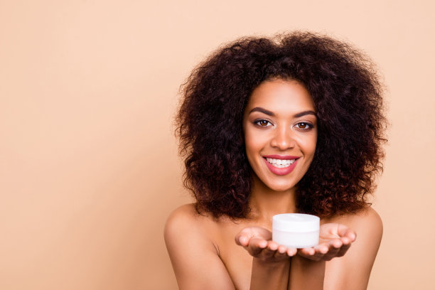 近距离的照片美丽，惊人的她，她的黑皮肤，波浪的模特女士介绍，促进手，手臂，新的每日面霜，建议购买，白色的牙齿，，孤立的米色，柔和的背景图片下载