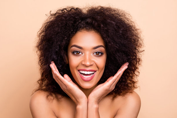 近距离的照片美丽的她，她的黑皮肤，模特，波浪的发型，手掌，脸颊喜出望外的结果，霜的行动，手表，镜子，沐浴，淋浴，审美纯净的皮肤，穿什么孤立的，柔和的米色背景图片下载