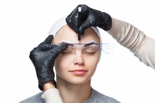 化妆师为年轻女孩画眉，打造精致眉形。专业化妆和皮肤护理图片下载