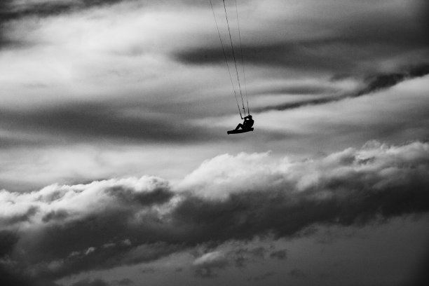 冬季风暴中进行风筝冲浪，极高的跳跃，云中冲浪，黑白戏剧效果图片下载