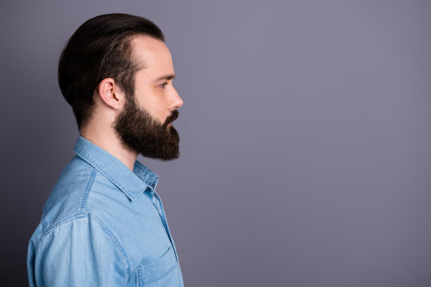 惊人的男子气概的个人资料照片，严肃的完美的外观整洁的长发鬃毛年轻的首席，看空的空间穿休闲牛仔装孤立的灰色背景图片下载