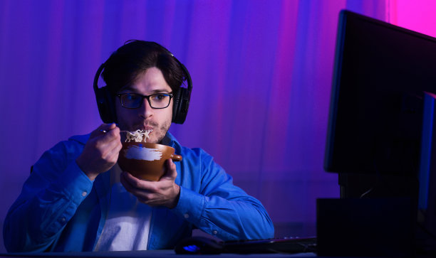 游戏玩家在家玩在线游戏时吃面条图片下载